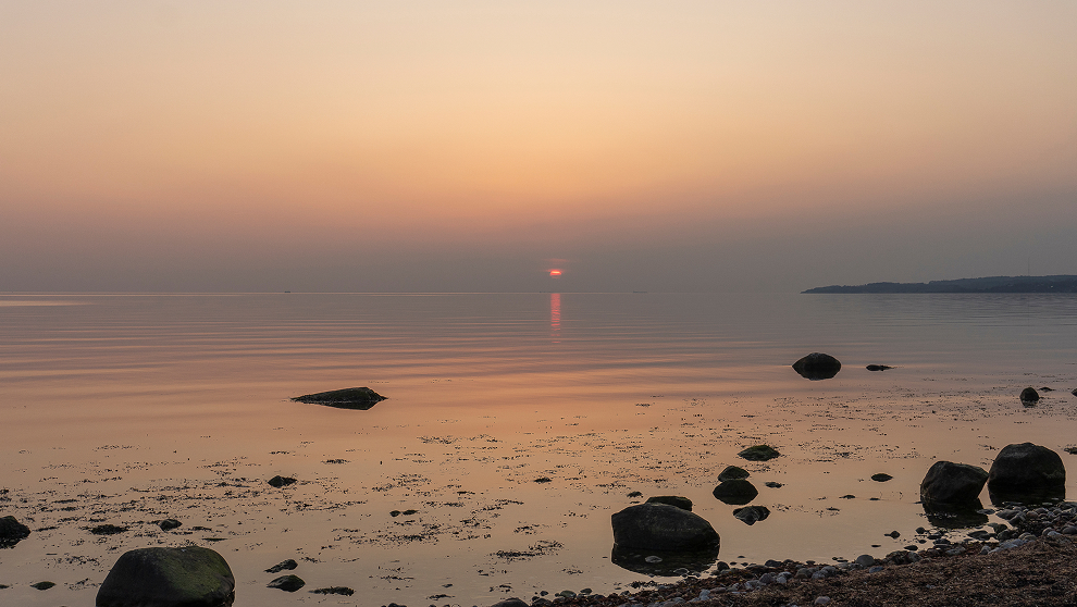 Wenn es nach einem Sonnenuntergang erst so richtig losgeht – eingehüllt in die Umgebung, am Kalundborg Fjord an der Westküste Seelands, Dänemark.